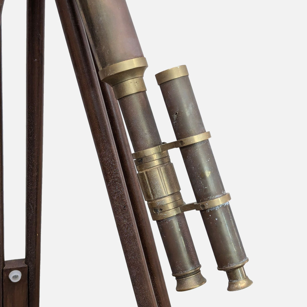 Close-up of brass telescope lenses on a vintage tripod stand.