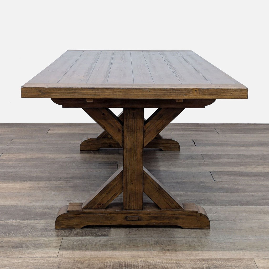 3. End view of Reperch farmhouse dining table, highlighting the wooden trestle base and textured tabletop.