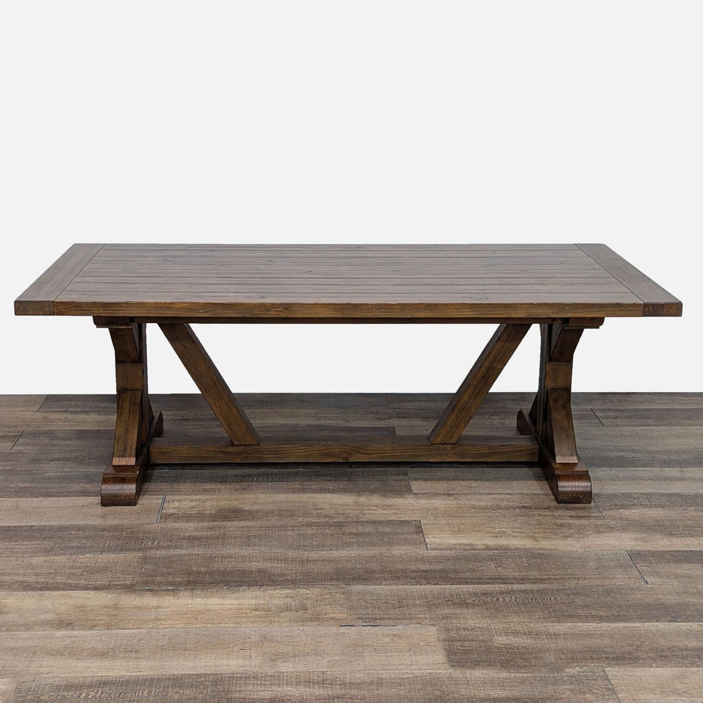 Wood dining table with trestle base and matching benches, ideal for a rustic decor.