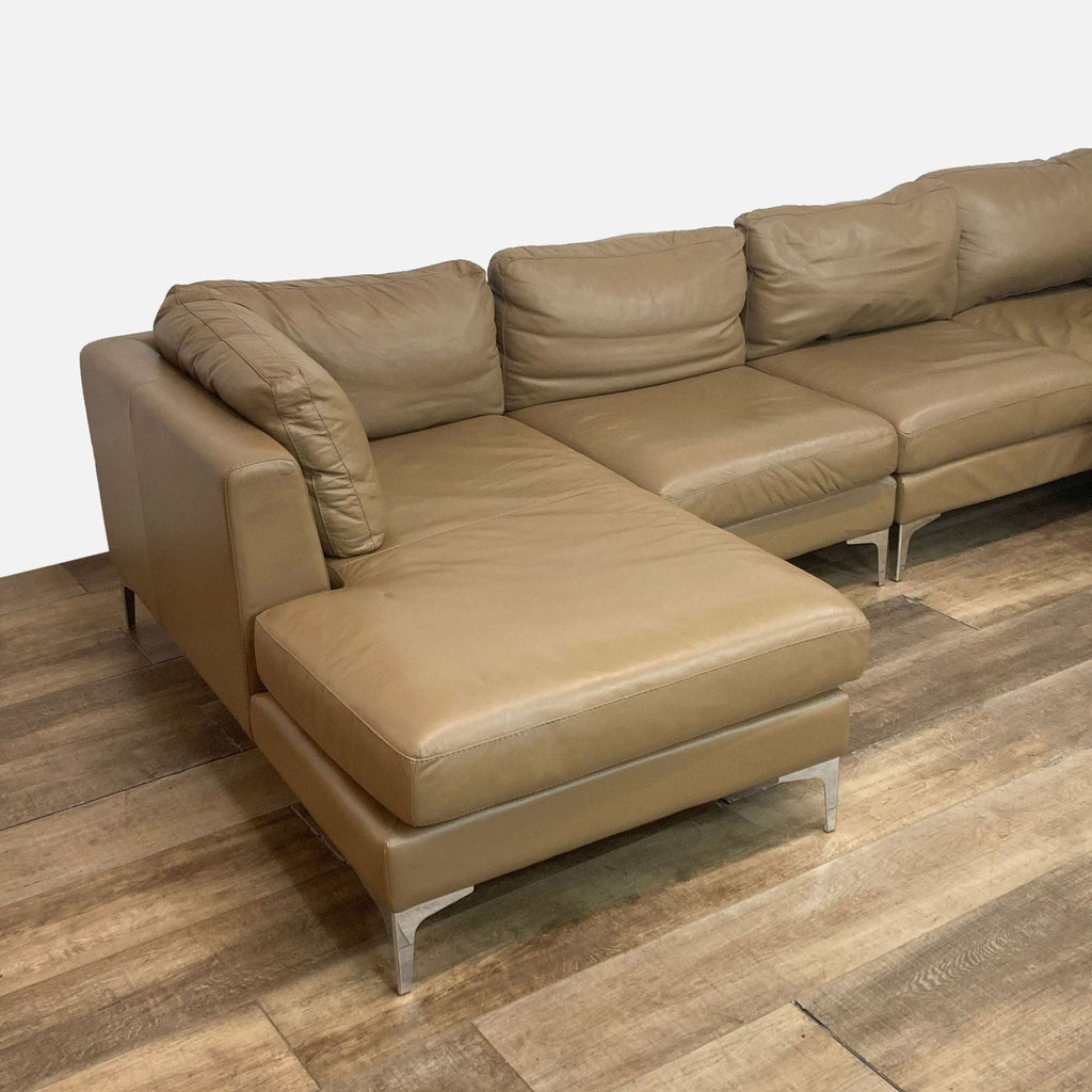 Left-arm chaise and armless seats on a light brown leather sectional sofa.