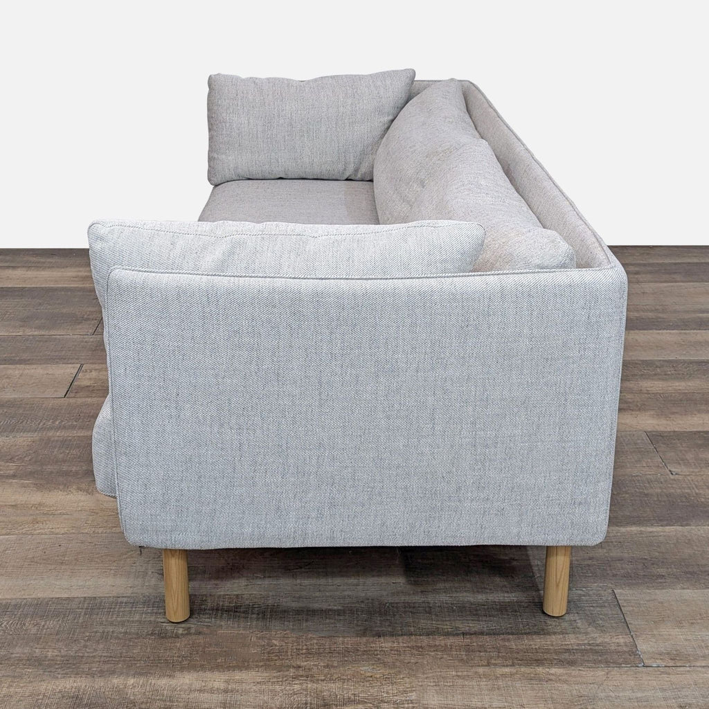 Angled side view of Wells sofa with tailored stitching and Gravel twill upholstery.