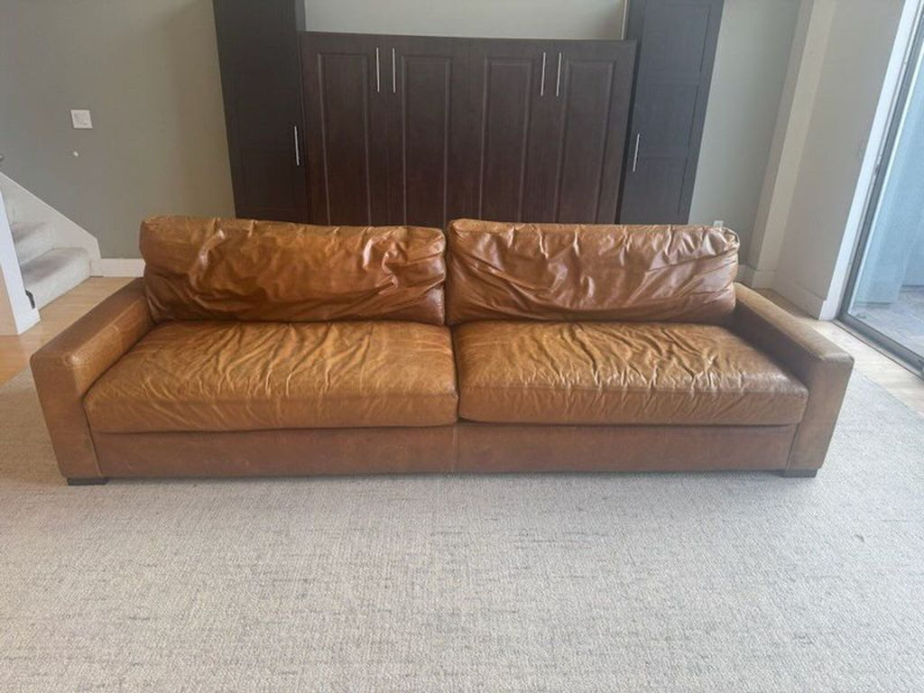 1. Maxwell Sofa 3-seat brown leather couch with wide arms and plush cushions, shown in a modern living space.