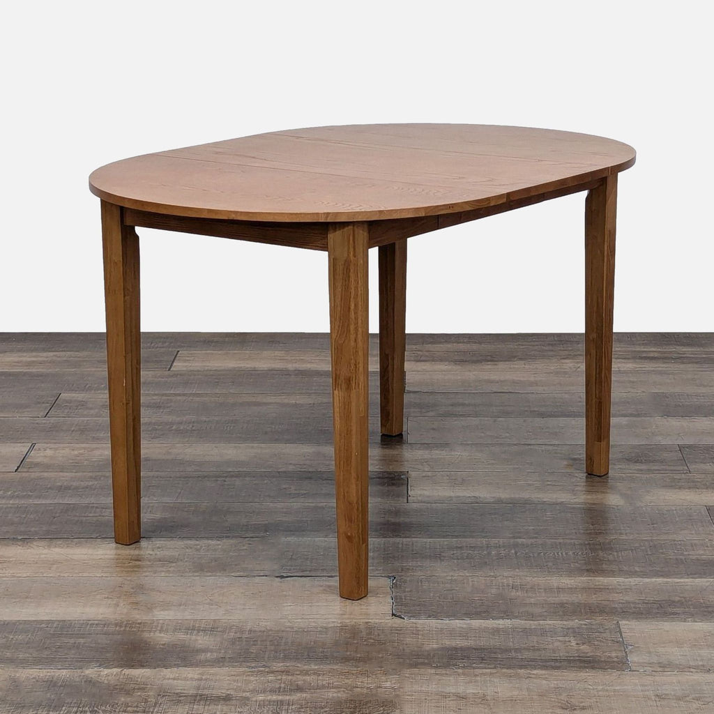 Side view of extended Litfad dining table on a wooden floor.