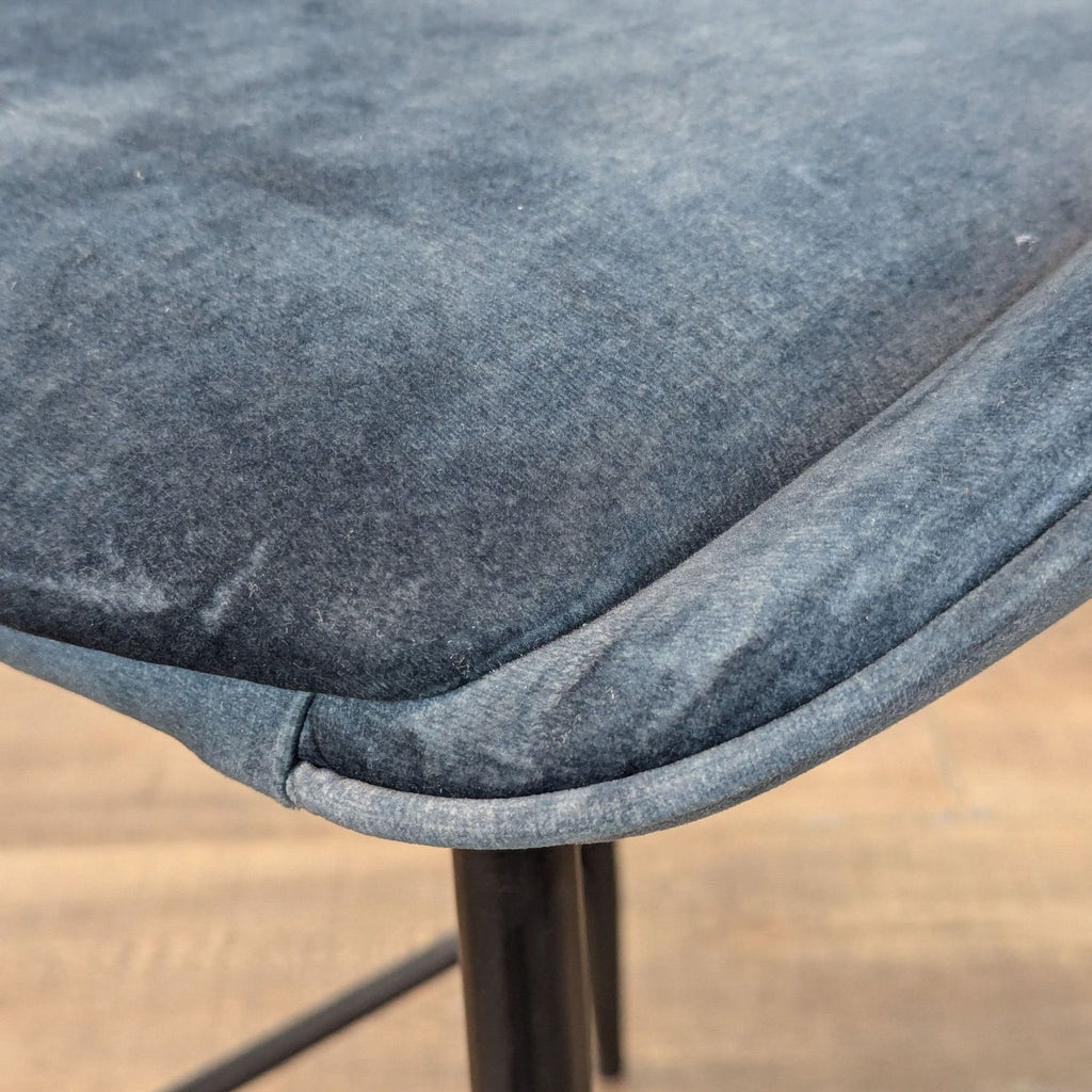Close-up of blue upholstered seat on Reperch stool.