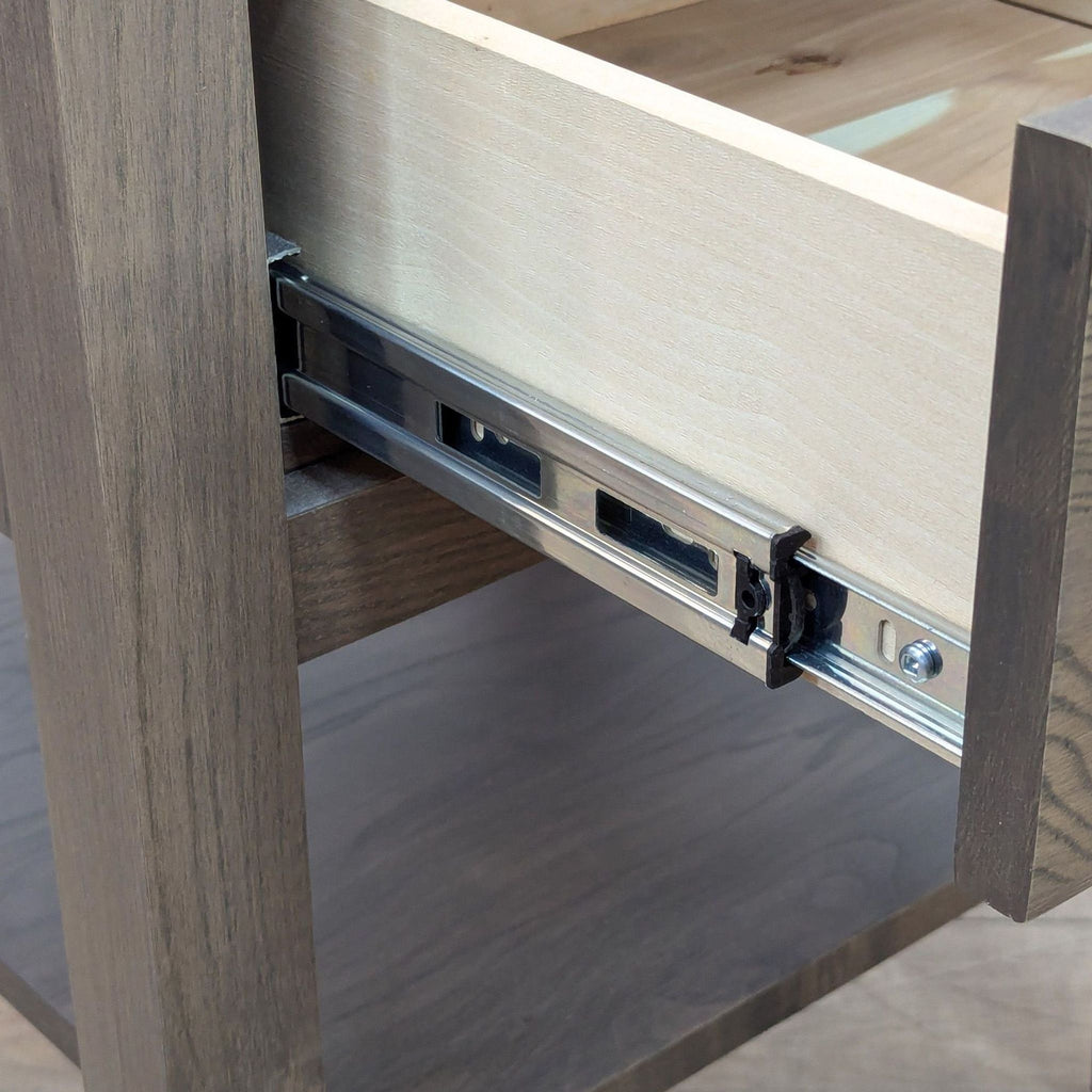 Close-up of metal sliding mechanism inside Room & Board end table drawer.