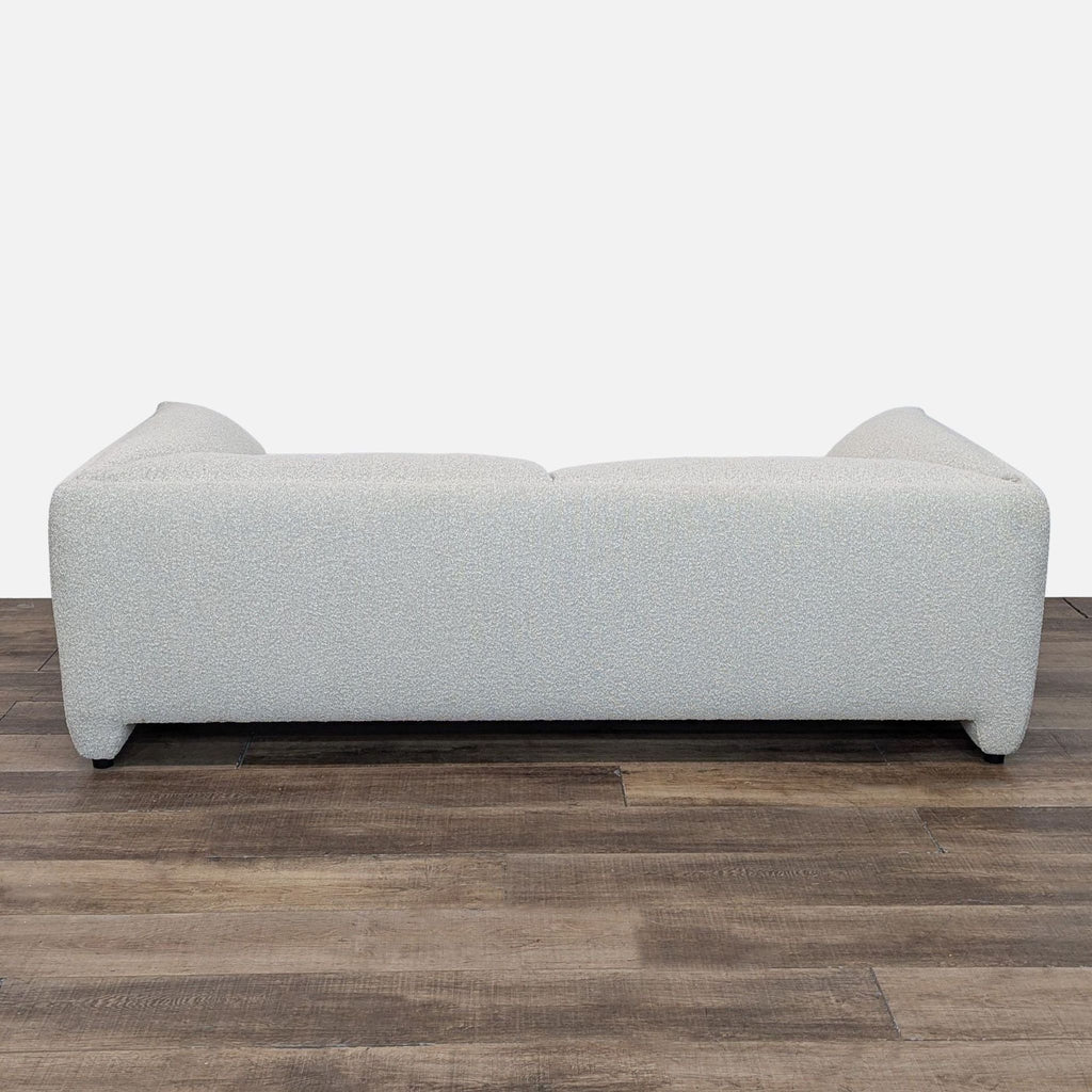 Back view of Castlery's Lucas sofa in white stain-resistant Bouclè fabric, placed on a wooden floor.