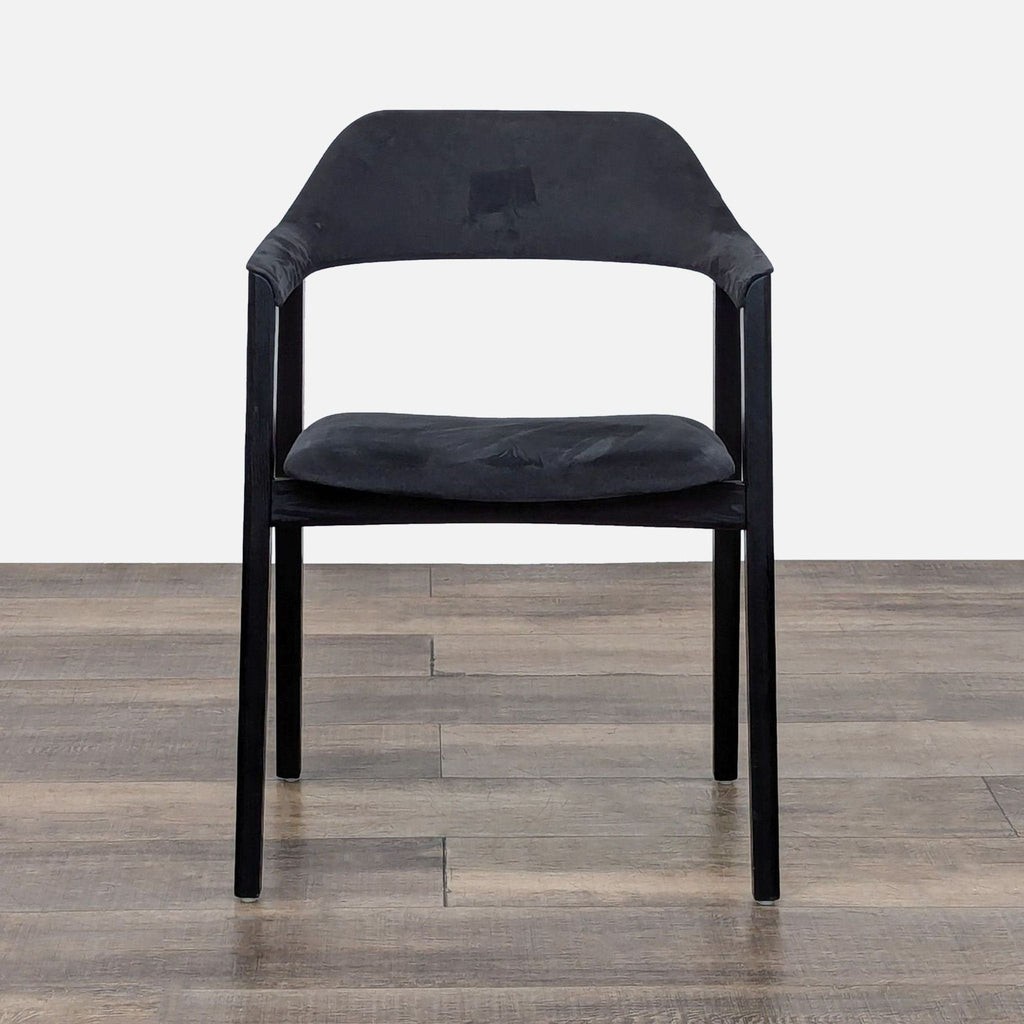 Front view of a black leather dining chair with walnut frame.