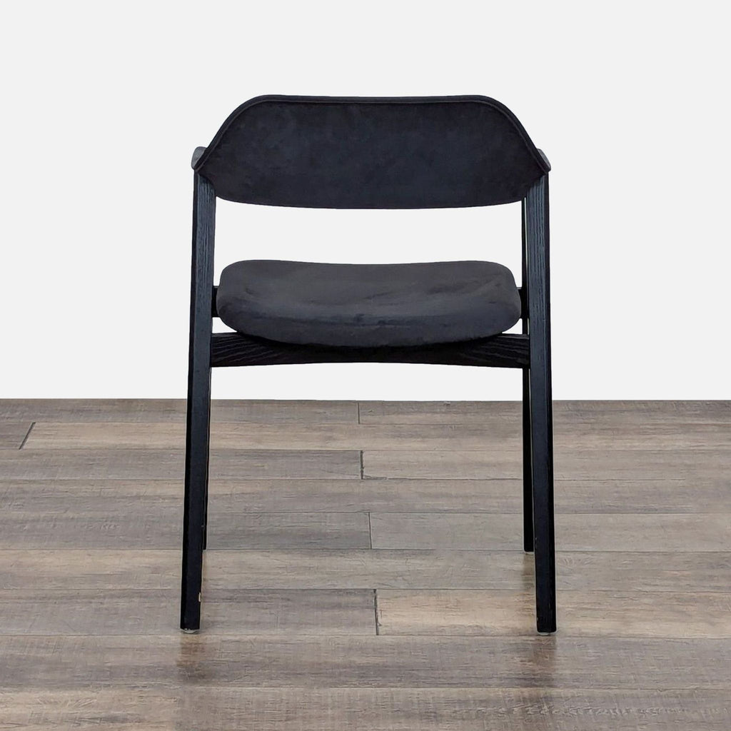 Back view of a dining chair with resin-treated black leather upholstery.