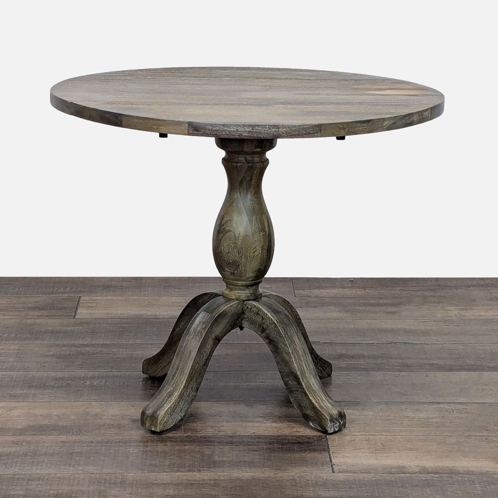 Round, laminated wood drop leaf table with pedestal base, by World Market.