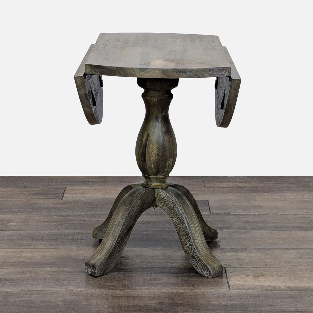 Side view of drop leaf table with leaves down, showing pedestal design.