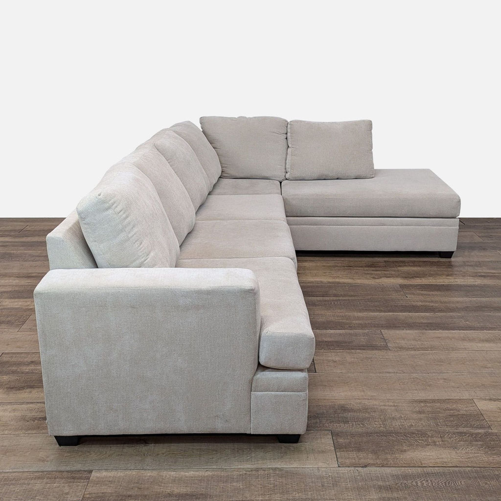 Side view of Bonaterra sectional featuring loose cushions and track arms on wooden flooring.