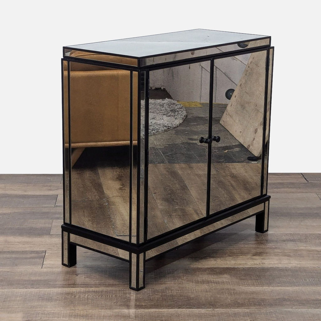 Side view of a reflective, mirrored cabinet on a wooden floor, with room reflections.