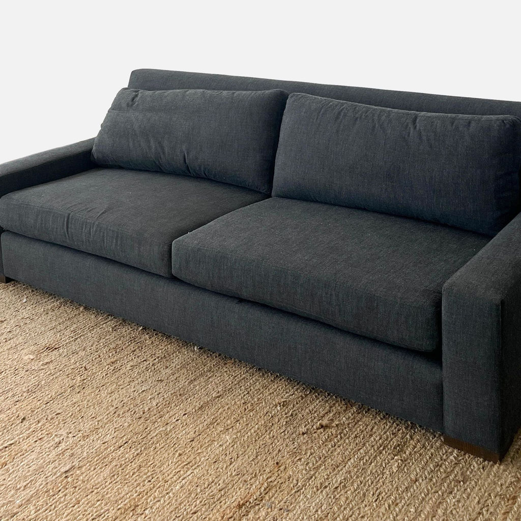 Reperch 3-seat sofa featuring track arms, loose cushions, and wood feet, placed on a textured rug.