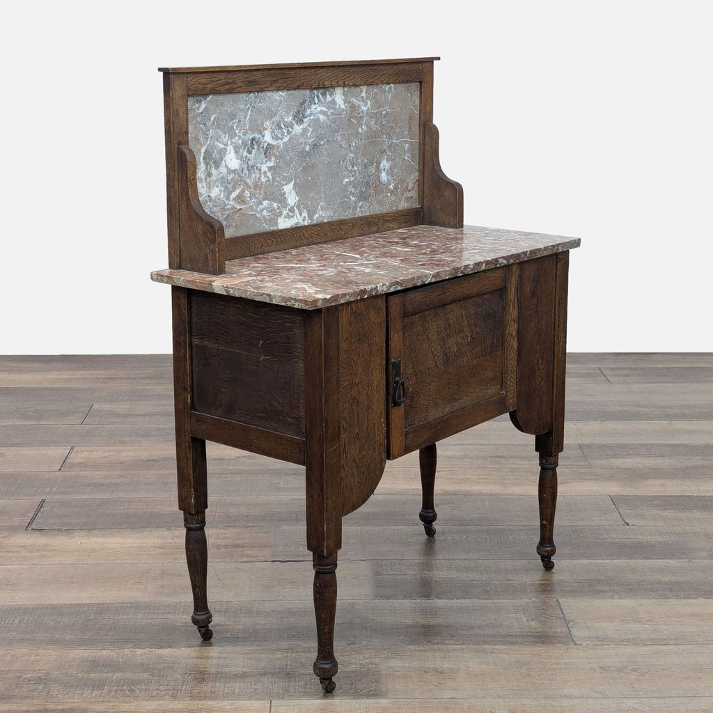 Early 20th-century washstand with marble top and oak in walnut finish, featuring a storage cabinet.