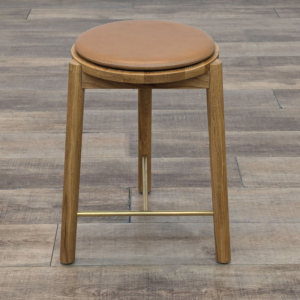 Top view of a wooden stool with a round leather cushion.