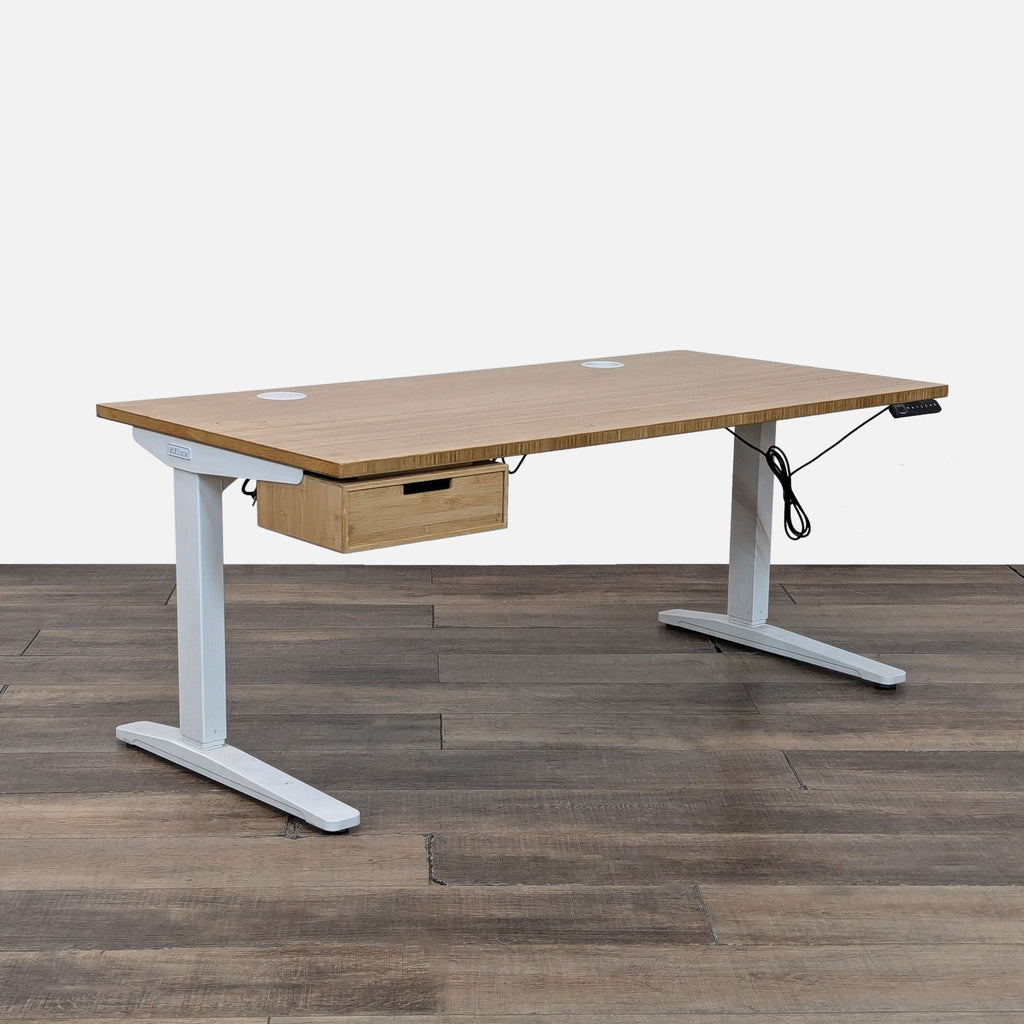 Bamboo-topped Uplift standing desk, featuring a white metal base, drawer, and power grommets.