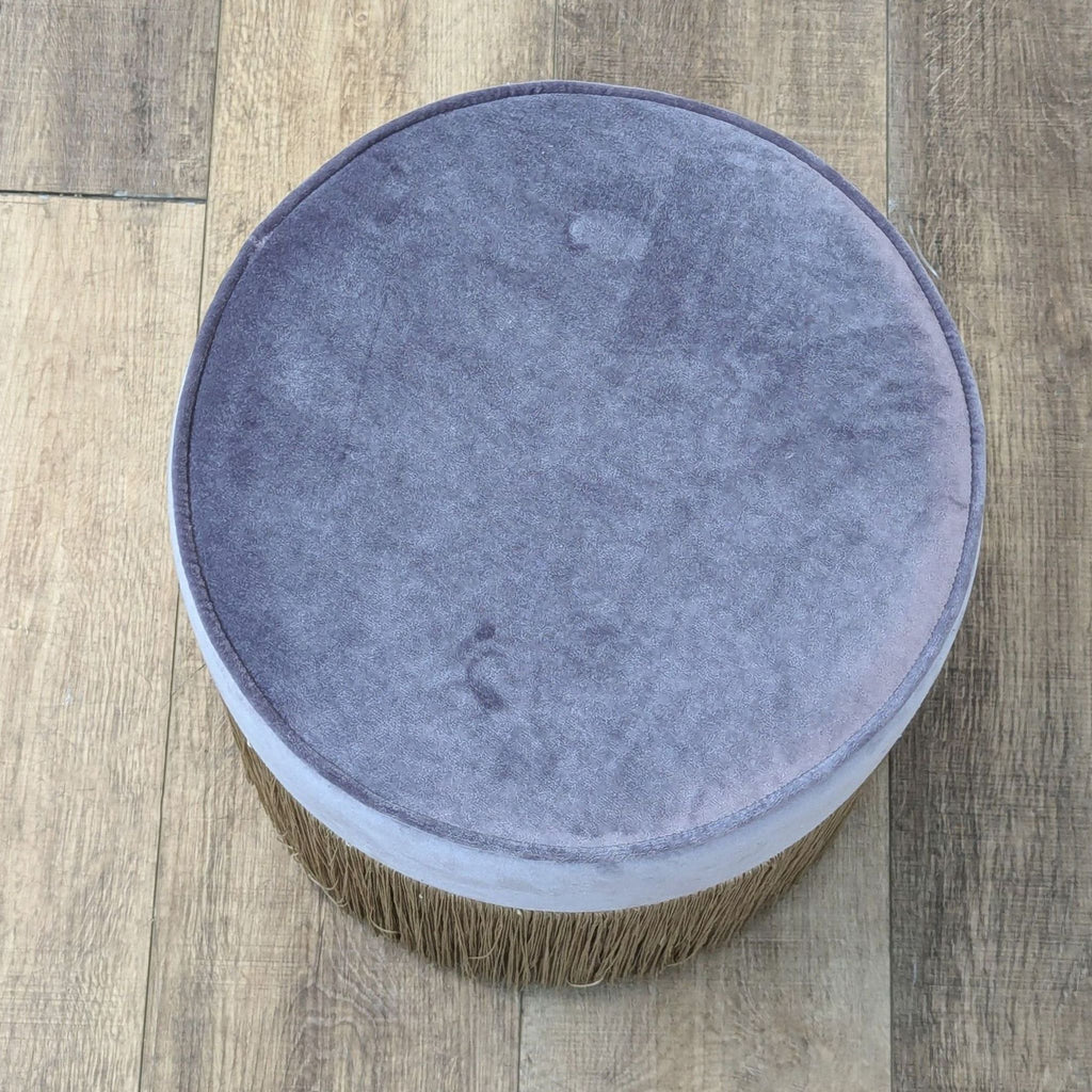 Top view of a plush velvet stool with fringe detailing.