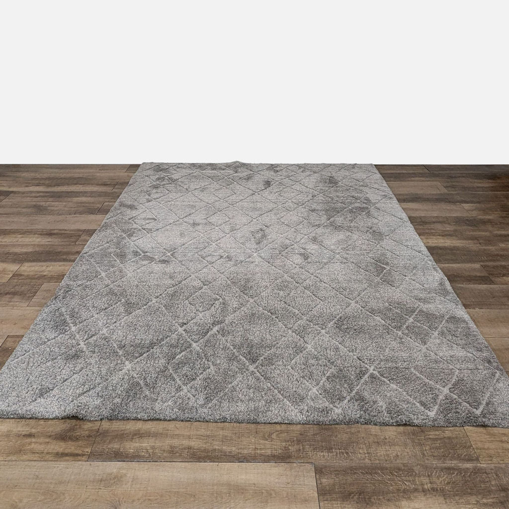 Gray polyester area rug with a dense pile and diamond pattern on wooden flooring.