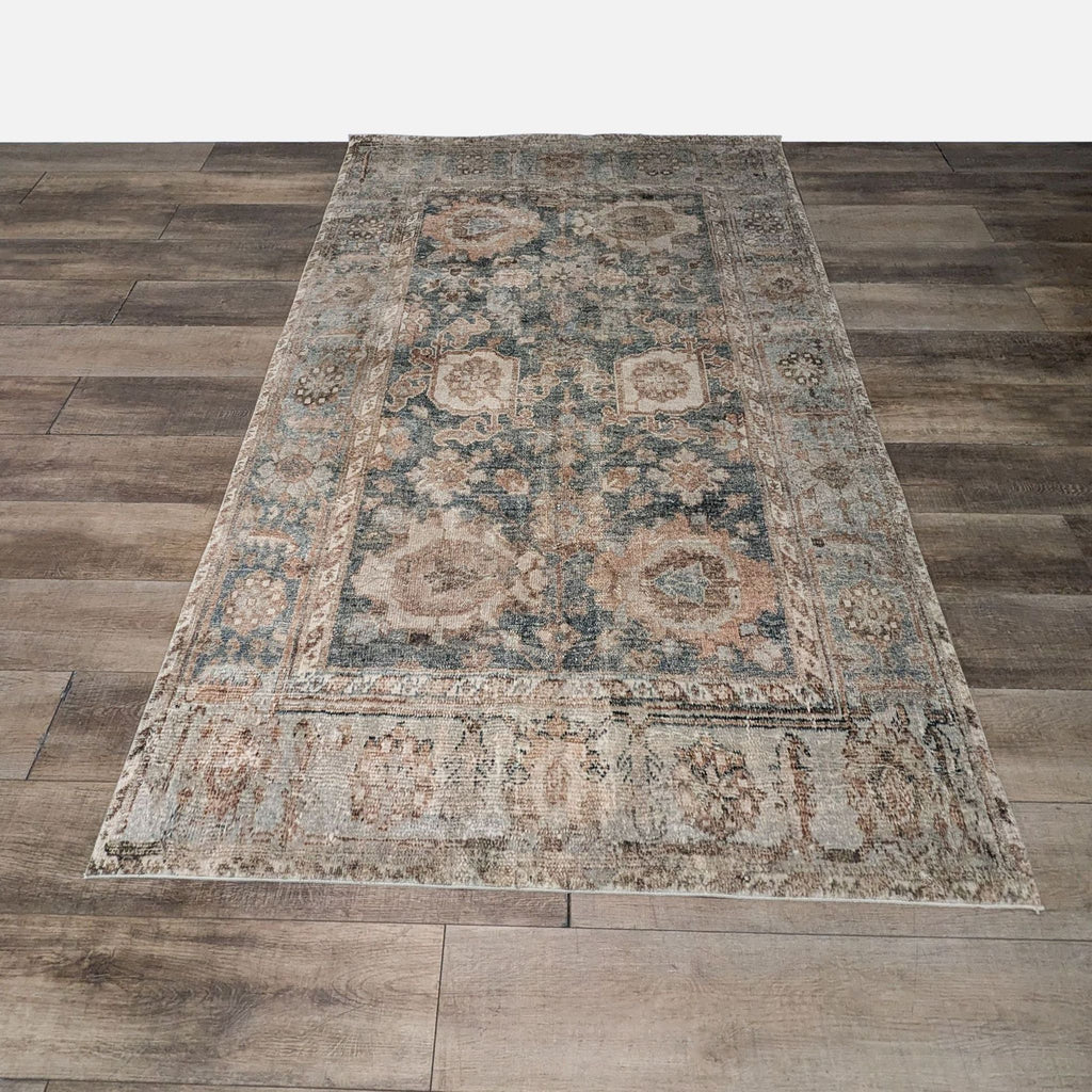 1. Rug with distressed Persian-style design in ocean blue, tan, and rust on wooden floor.