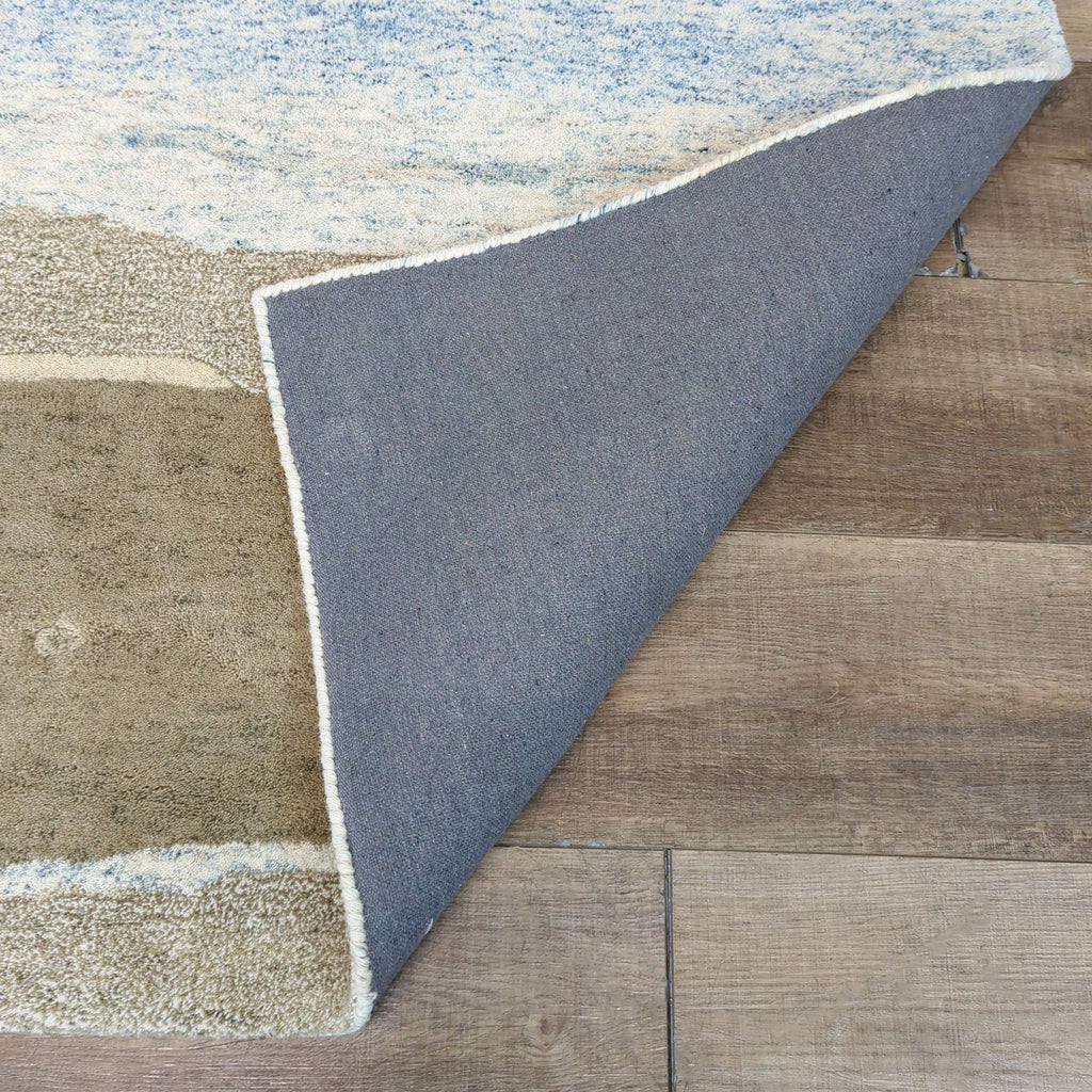 Close-up of the Meadow rug folded corner, showing wool texture and backing details.