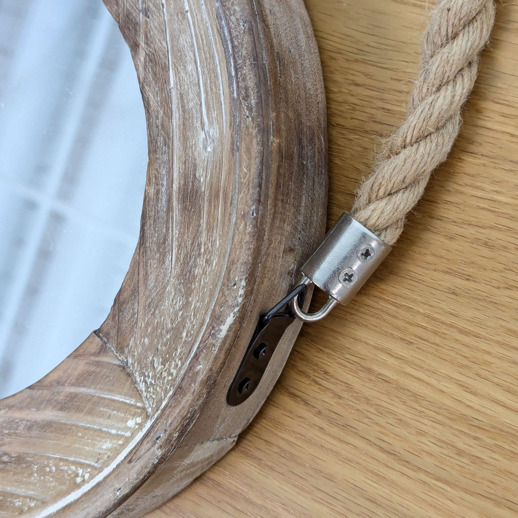 Close-up of the wooden frame and rope attachment details of a Heritage Home round mirror.