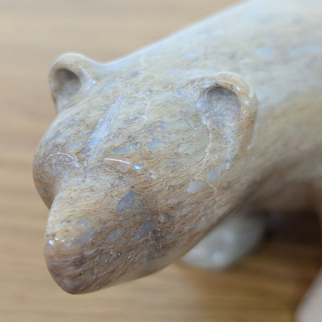 Close-up of a soapstone bear's head, highlighting texture and details.