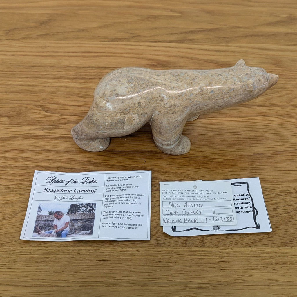 A soapstone bear sculpture by a Canadian Inuk artist on a wooden surface.