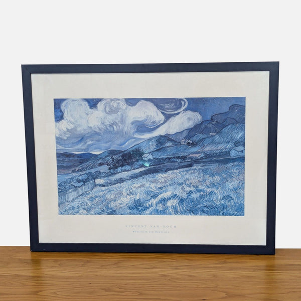 Framed Van Gogh print of "Wheatfield and Mountains," showcasing vivid blue landscapes.  