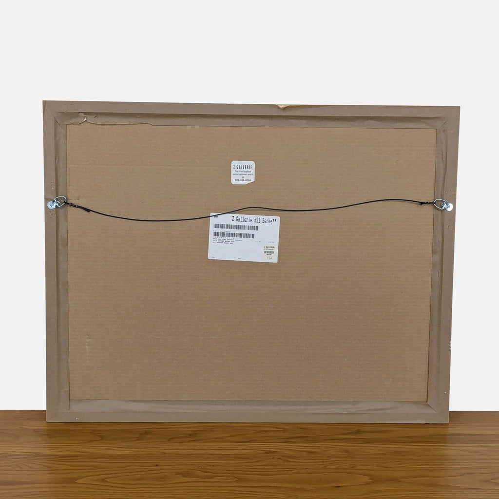 Back view of a framed art print with hanging wire and labels.