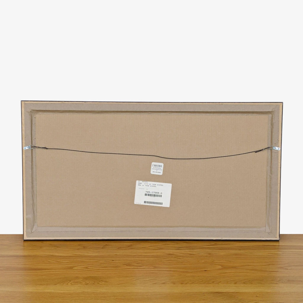 "Back of a framed print with hanging wire and labels visible."