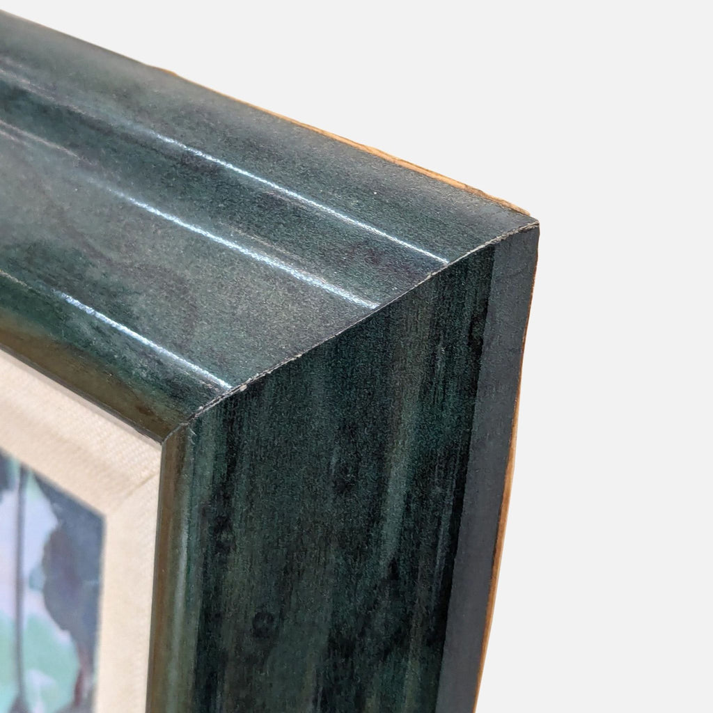 Corner view of the dark wooden frame surrounding the tropical painting.