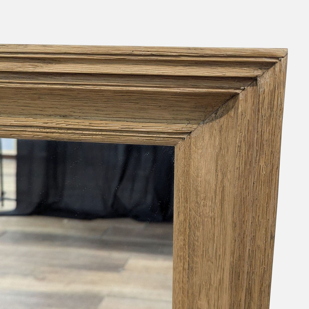Close-up of Reperch mirror highlighting the detailed wooden frame corner on wooden floor background.