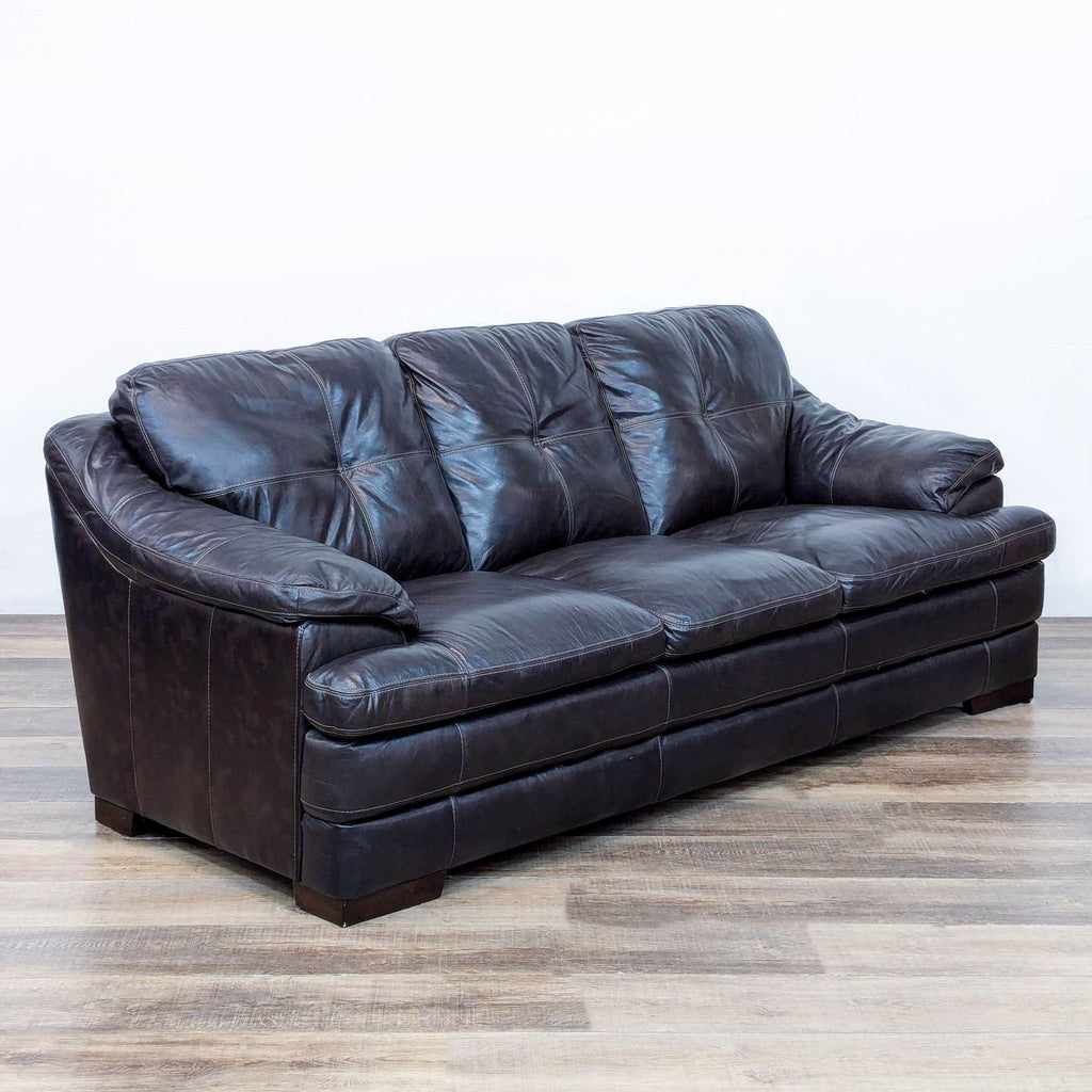 Angled view of a Reperch 3-seat sofa with dark leather upholstery and button-tufted cushions.