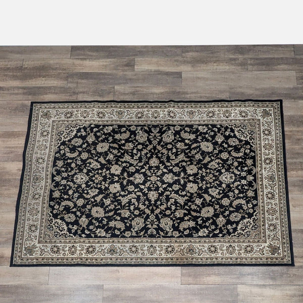 Floral wool area rug in Kashan Black by Florence Carpet, on a wooden floor.