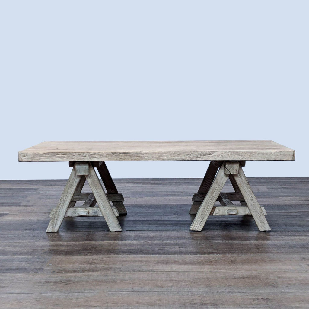 Rustic wooden coffee table with trestle legs by Restoration Hardware.