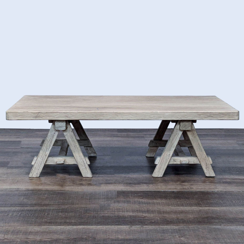 Side view of a Restoration Hardware coffee table featuring a sturdy trestle base.