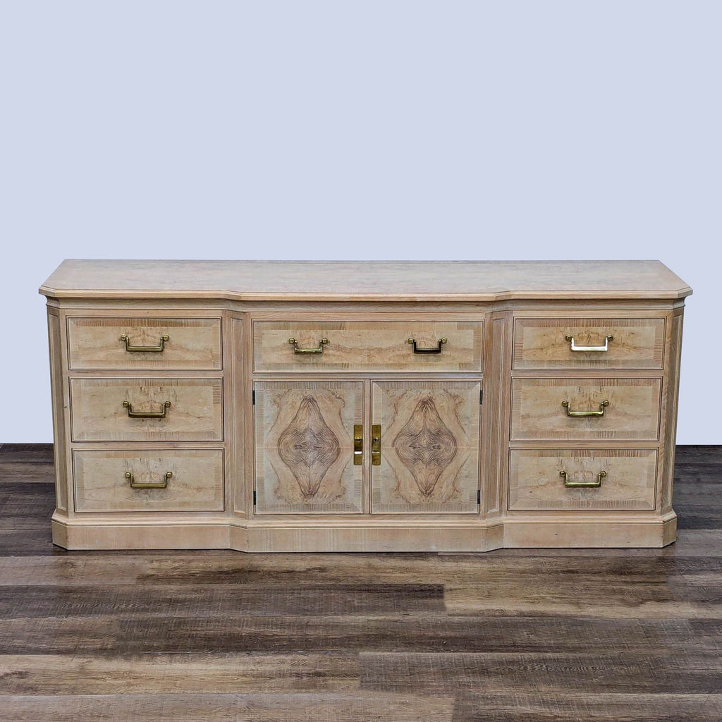 Light wood Drexel Heritage dresser with nine drawers, brass handles, and center cabinet for storage.