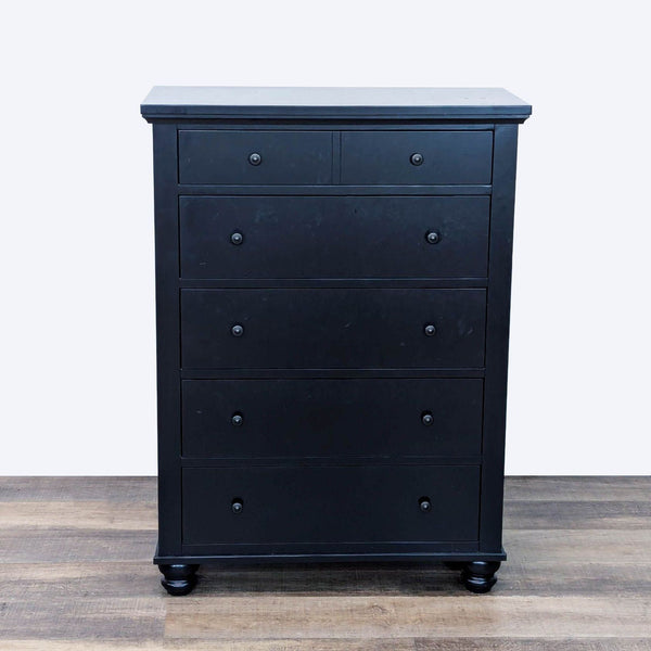 Black dresser with 5 drawers, dovetail joinery, metal glides, and turned wood feet.