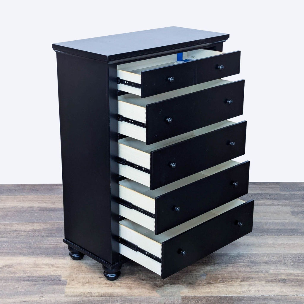 Side view of black dresser showing all drawers open, revealing dovetail joinery on metal glides.