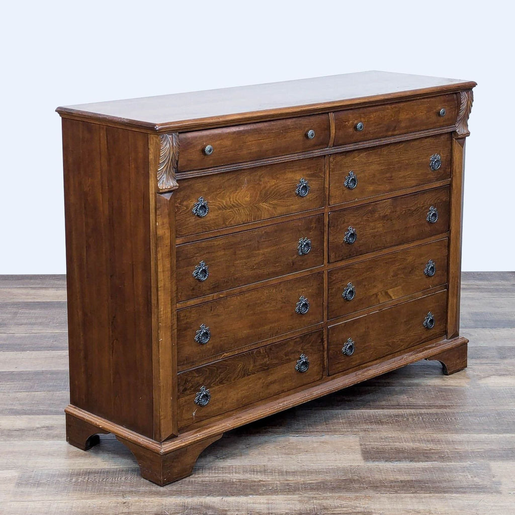 Side view of dresser with intricate woodwork and 10 drawers with ring pulls.