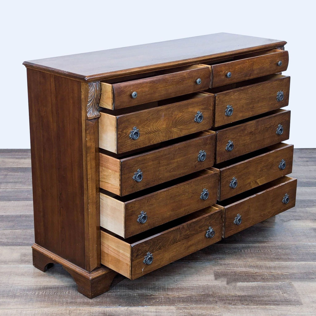 Open drawers of a wooden dresser with drop ring pulls reveal dovetail joinery.