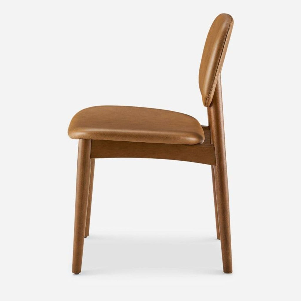 Side view of a caramel leather dining chair featuring solid rubberwood legs.