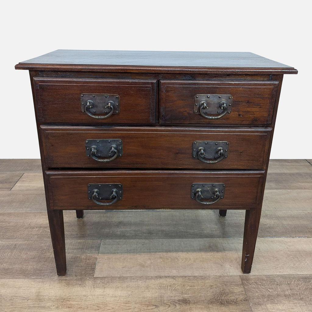 Dark-finished dresser with tall legs and metal pulls, by Reperch.