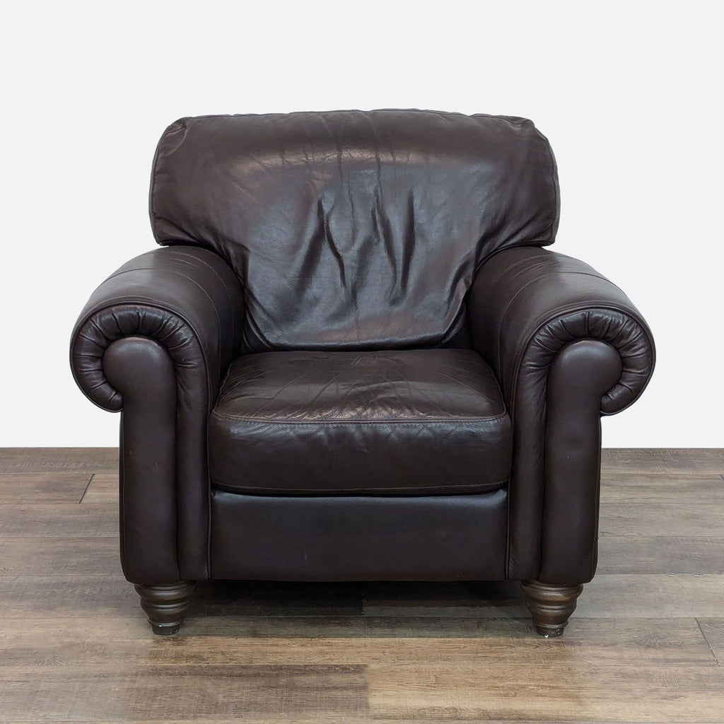 Front view of Natuzzi leather chair with rolled arms and turned wood feet.