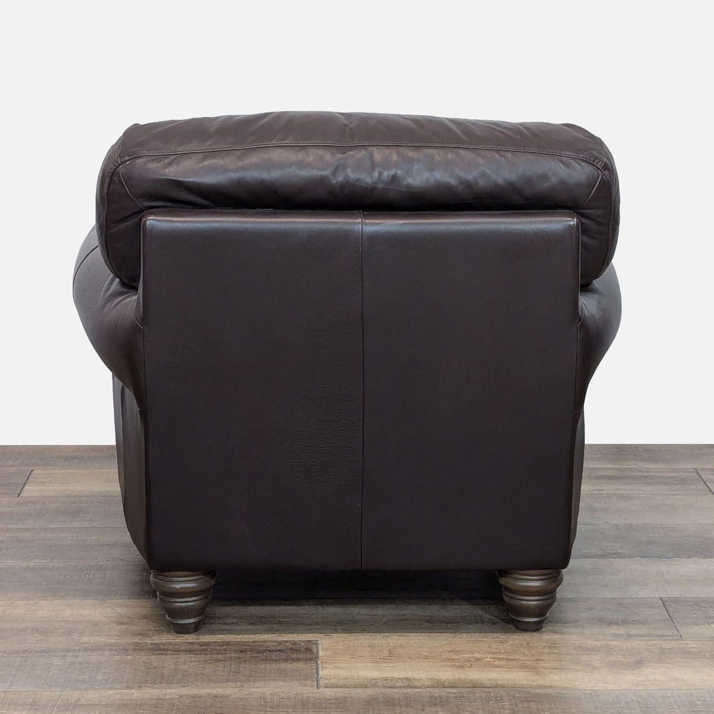 Back view of Natuzzi chair highlighting smooth leather finish and sturdy wood feet.