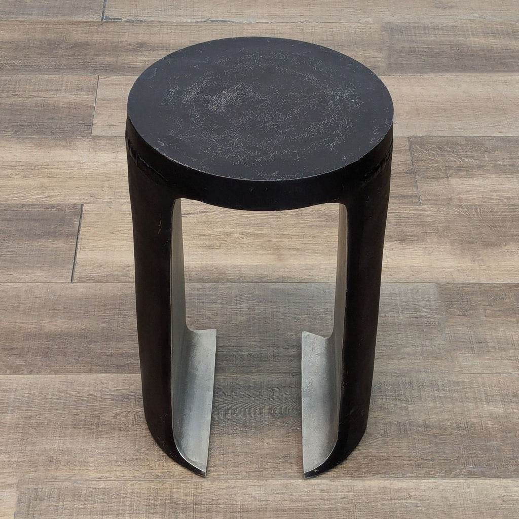 Top view of Reperch's black end table, showcasing the smooth round surface and open base design.