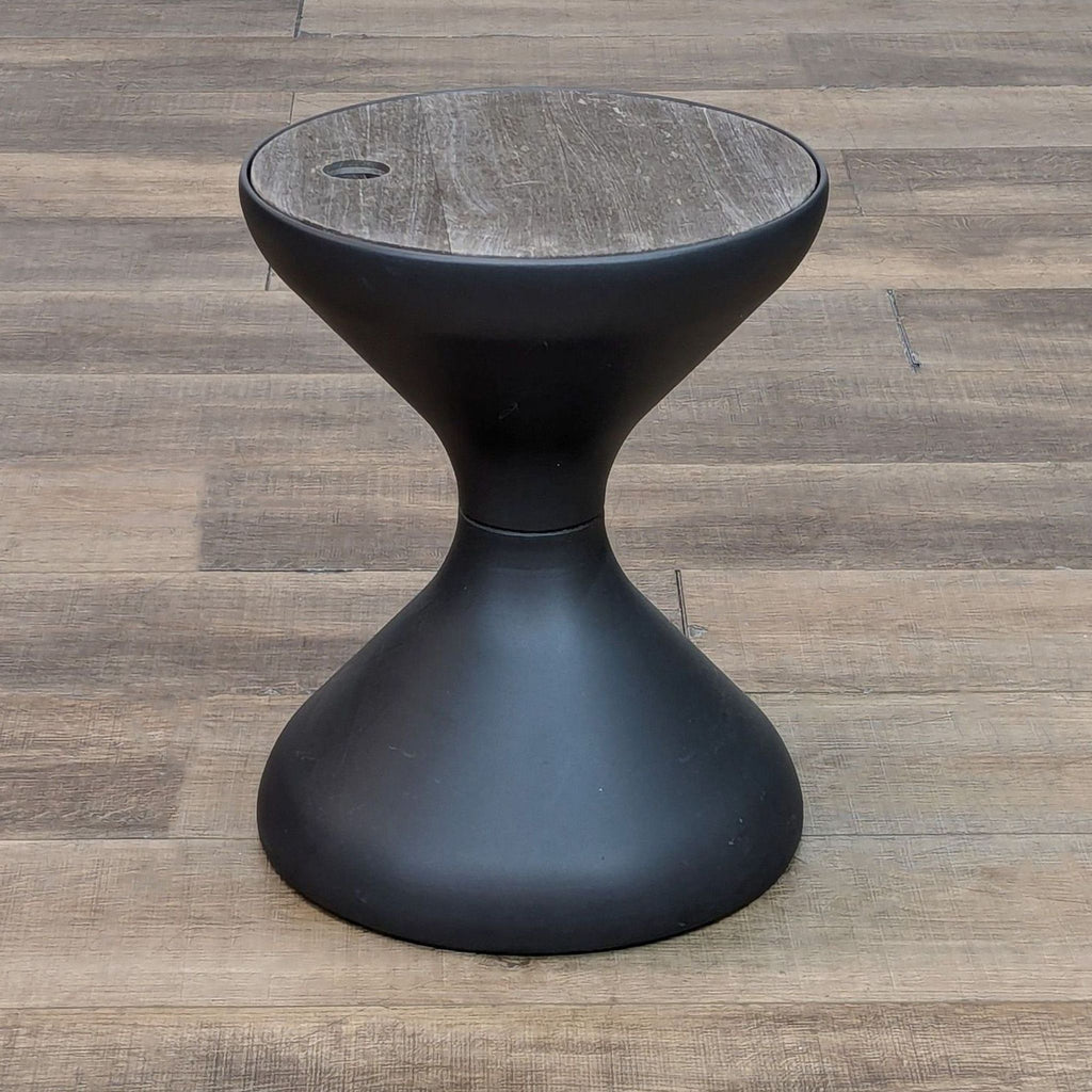 Hourglass side table with natural teak top and ice bucket, on a wood floor.  