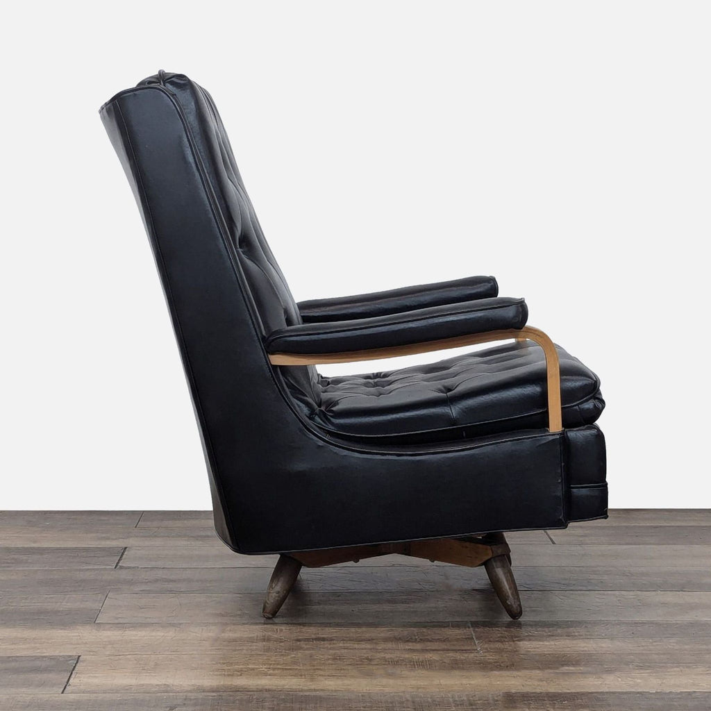 Side view of a Reperch black leather lounge chair showing tufted design and wood accents.  