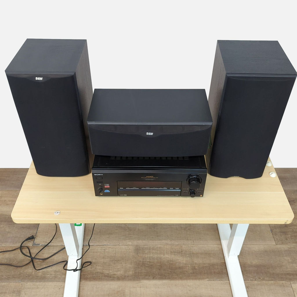 Top view of a Sony and B&W audio setup featuring speakers and an amplifier on a wooden table.