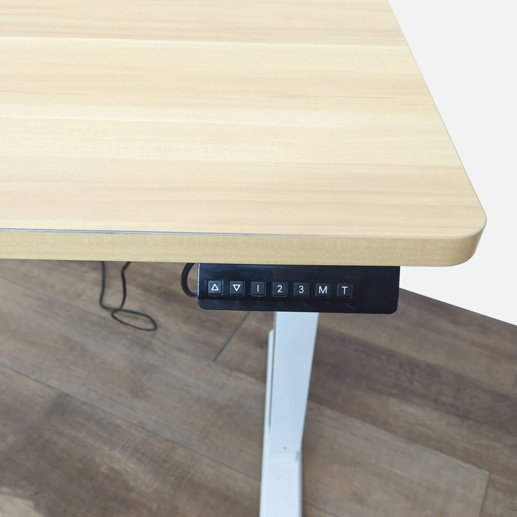 Adjustable height desk with control panel, T-base design, and wood laminate surface.